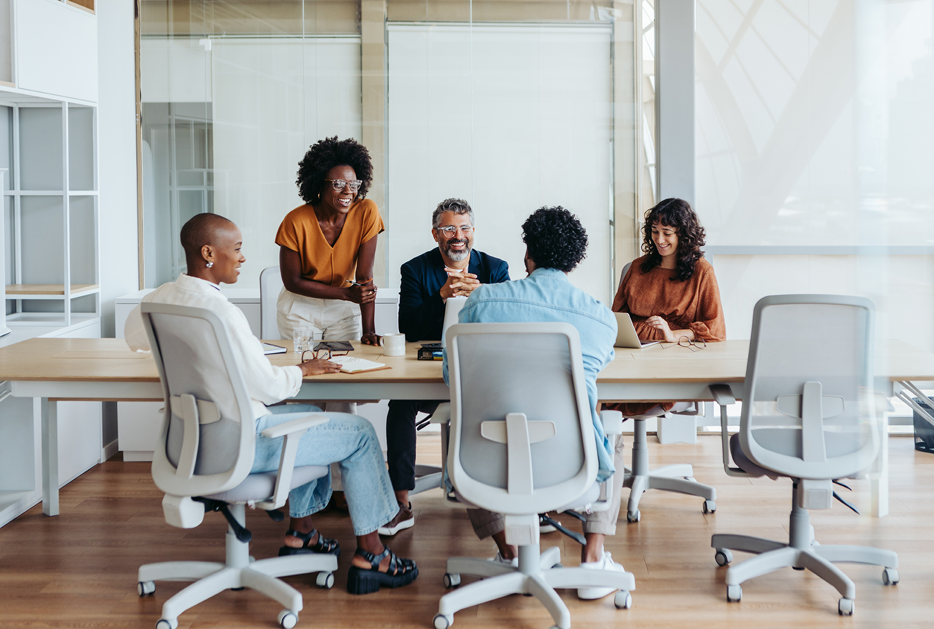 Business people in a boardroom engage in a productive discussion, collaborating on a project. Team members, both men and women, share ideas and plan together. A creative workplace environment showcases successful teamwork.
